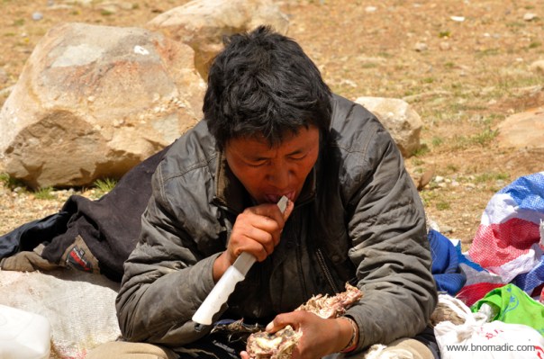 A Tibetan feasting on a dried meat at the end of the Kora